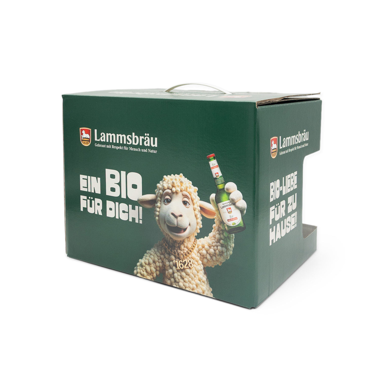 Grüne Lammsbräu-Geschenkbox mit Tragegriff in Seitenansicht auf weißem Hintergrund. Die Vorderseite zeigt das Lammsbräu-Logo oben, weißen Text "EIN BIO FÜR DICH!" in großen Buchstaben, eine Illustration eines lachenden Lamms mit cremefarbenem lockigem Fell und eine Lammsbräu-Bierflasche.