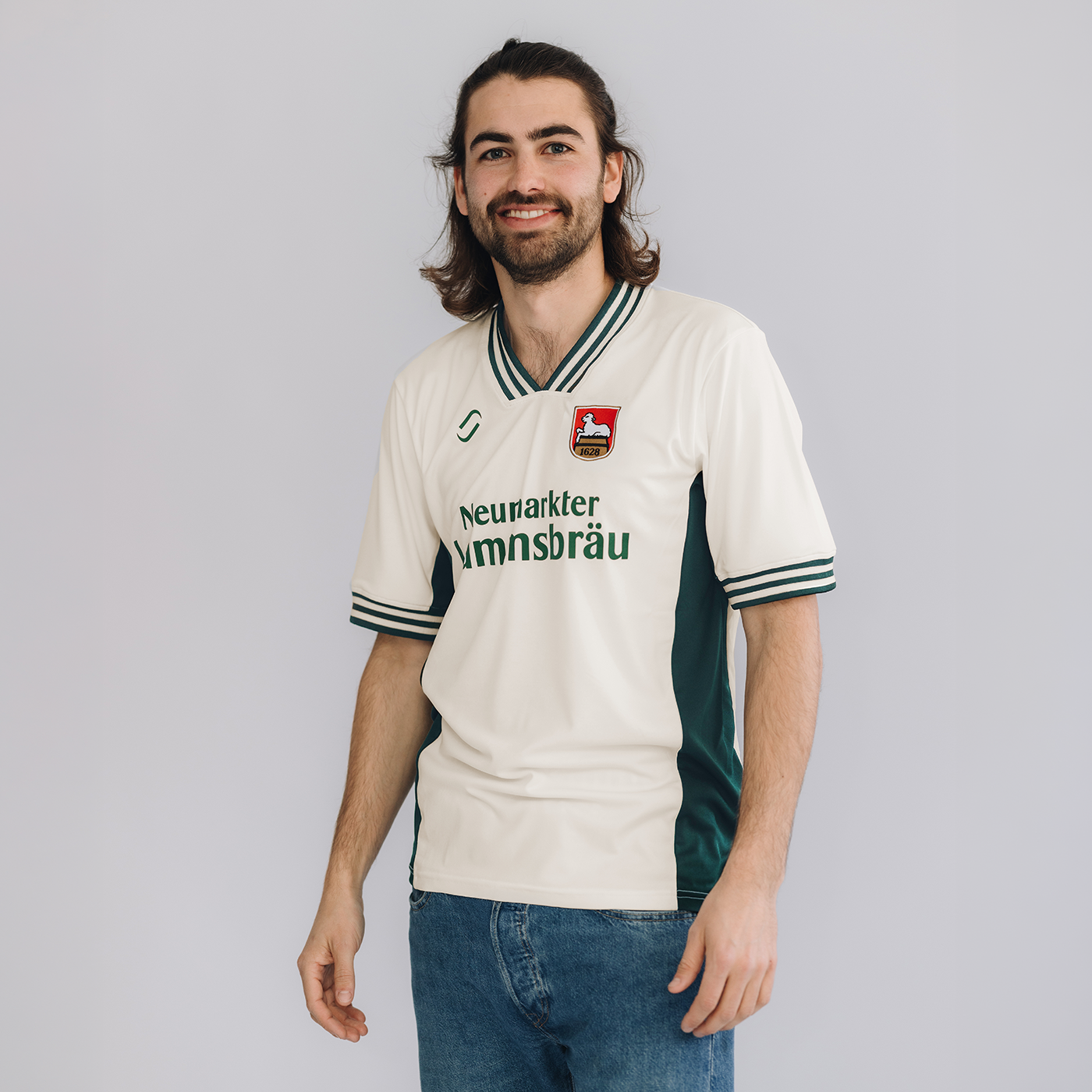 Ein männliches Model trägt ein Retro-Fußballtrikot. Das Trikot ist im Farbton "elfenbein" und hat auf der Brust den Schriftzug "Neumarkter Lammsbräu". Außerdem sind das Logo von runamics und das Logo von Lammsbräu auf dem Trikot integriert.