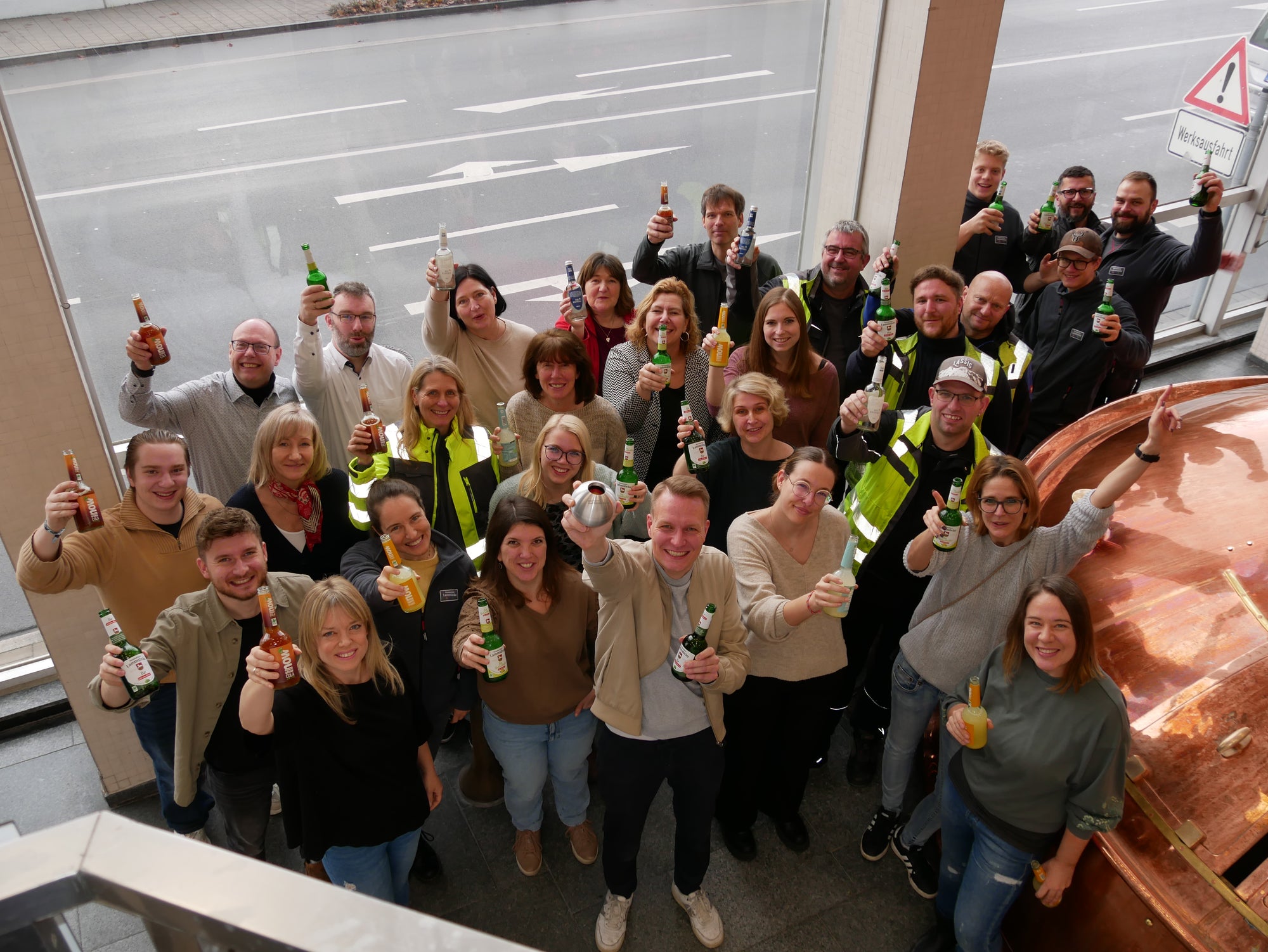 Mitarbeitende der Lammsbräu im Sudhaus mit now Limos und Bio-Bier zuprostend